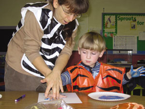 Mrs. Frohmee demonstrating proper handpainting techniques to Carsten